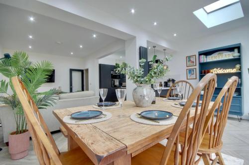 a dining room with a wooden table and chairs at Clover lodge Portsmouth luxury home with off road free parking in Portsmouth