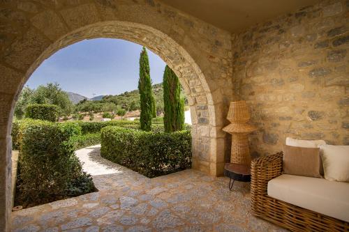 an archway in a room with a couch and trees at BASSA MAINA Villas & Suites in Areopolis