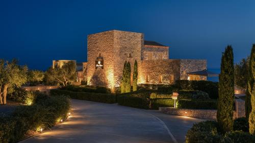 a large stone building with lights on a driveway at BASSA MAINA Villas & Suites in Areopolis