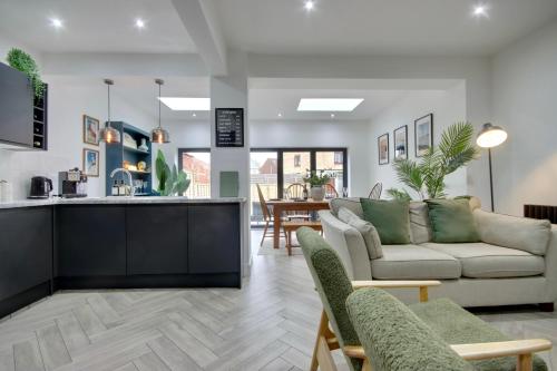 a living room with a couch and a kitchen at Clover lodge Portsmouth luxury home with off road free parking in Portsmouth