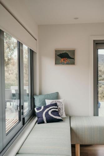 a living room with a couch and a window at The Tides in Coles Bay