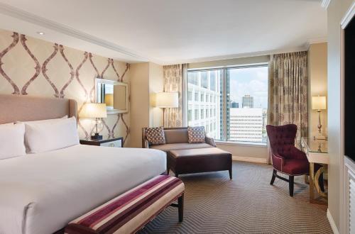 a hotel room with a bed and a chair and a window at Harrah's New Orleans Hotel & Casino - A Caesars Rewards Destination in New Orleans