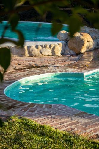 a swimming pool with blue water in a yard at Posada de Nono in Nono