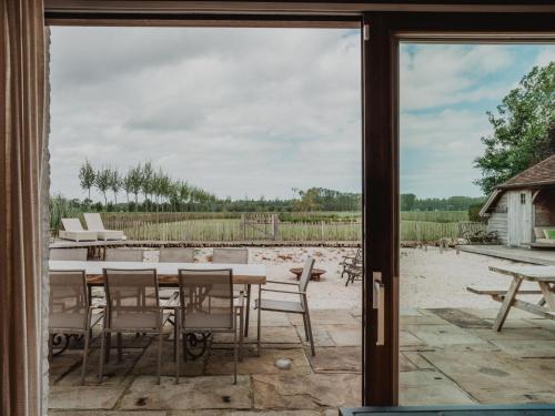 a patio with a table and chairs outside a window at Villa Noortem in Maldegem