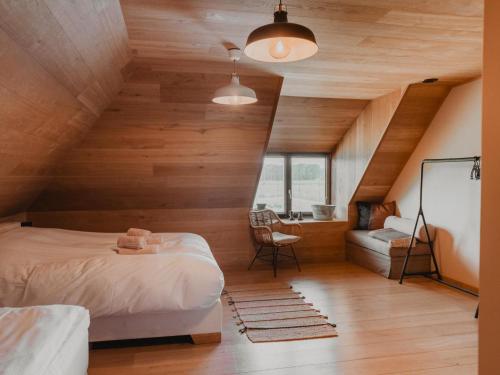 a attic bedroom with a bed and a desk at Villa Noortem in Maldegem