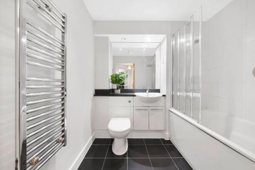 a white bathroom with a toilet and a sink at Cosy Modern1 Bed Apartment, by Excel London, City Airport & O2 in London