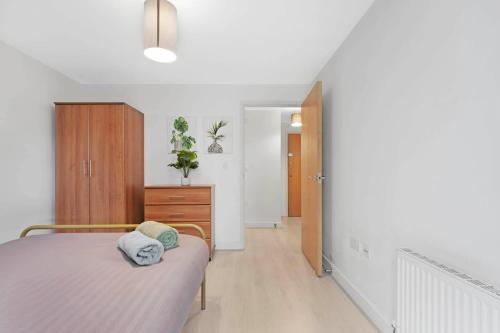 a bedroom with a bed and a dresser in it at Cosy Modern1 Bed Apartment, by Excel London, City Airport & O2 in London