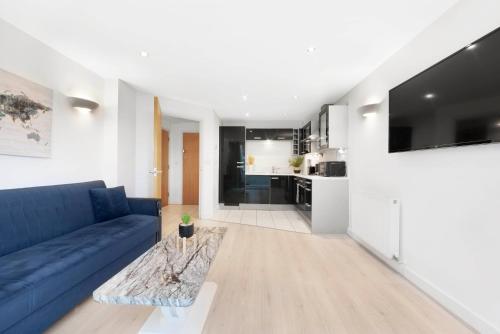 a living room with a blue couch and a table at Cosy Modern1 Bed Apartment, by Excel London, City Airport & O2 in London