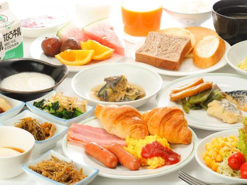 a table filled with plates of breakfast foods at Hotel Route Inn Tonami Inter in Tonami