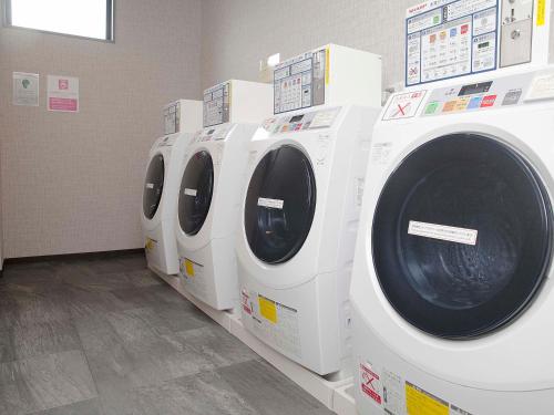 a row of white washing machines in a store at Hotel Route Inn Tonami Inter in Tonami