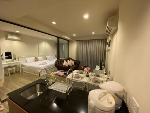 sala de estar con sofá y cama en una habitación en Rain Cha-am Huahin, en Cha Am