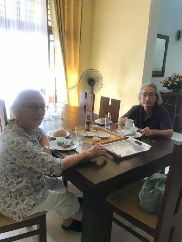 two older women sitting at a table eating food at Bigcity Villa - Airport Transit Hotel in Katunayake