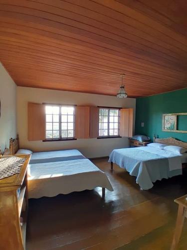 a large room with two beds in it at Casa Flamboiam in Tiradentes
