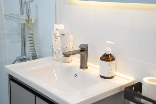 a bathroom sink with a bottle of soap on it at Shanghai Yi Du B&B - Family Suite 500m to Nanjing West Rd Near People's Square -Credit Cards Accepted in Shanghai