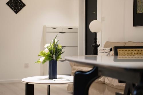 a table with a vase with white flowers on it at Shanghai Yi Du B&B - Family Suite 500m to Nanjing West Rd Near People's Square -Credit Cards Accepted in Shanghai