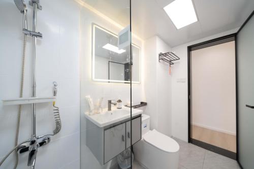 a white bathroom with a sink and a toilet at Shanghai Yi Du B&B - Family Suite 500m to Nanjing West Rd Near People's Square -Credit Cards Accepted in Shanghai