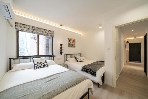 a bedroom with two beds and a window at Shanghai Yi Du B&B - Family Suite 500m to Nanjing West Rd Near People's Square -Credit Cards Accepted in Shanghai