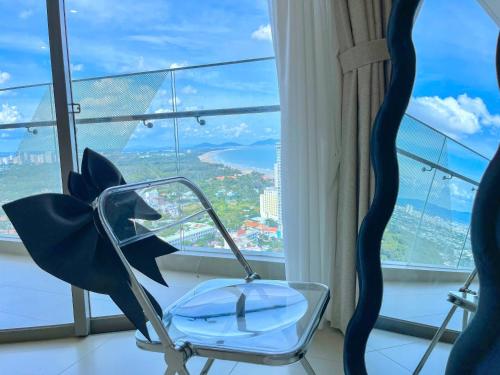 a chair in a room with a large window at The Song Boutique Apartment in Vung Tau