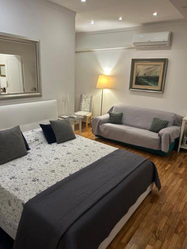 una camera da letto con un letto grande e un divano di Aurora 31 - Suite & Breakfast a Roma