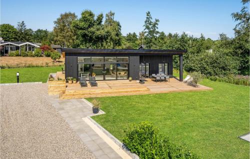 a modern house with a wooden deck and grass at Beach Front Home In Haderslev in Haderslev