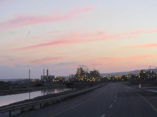 a highway with a city in the background at sunset at Rose Dead Sea Neve Zohar in Neve Zohar