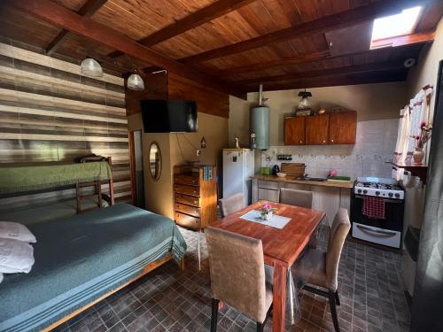 a kitchen with a table and a bed in a room at CABAÑAS MECHI in Mar del Plata