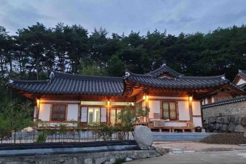 a house with a chinese roof on top of it at Lee Cho Hanok in Gyeongju