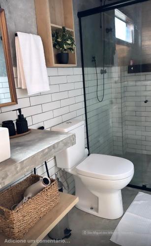 a bathroom with a toilet and a glass shower at Casa Flor São Miguel dos milagres 11 in Barra do Camaragibe