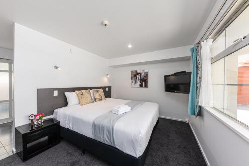 a bedroom with a bed and a flat screen tv at 315 Motel Riccarton in Christchurch