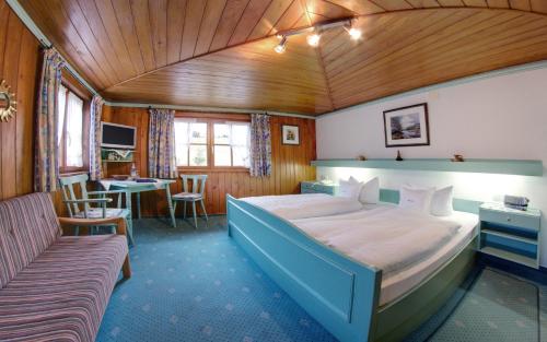 a bedroom with a large bed and a table at Ferienhotel Starennest in Schindelberg