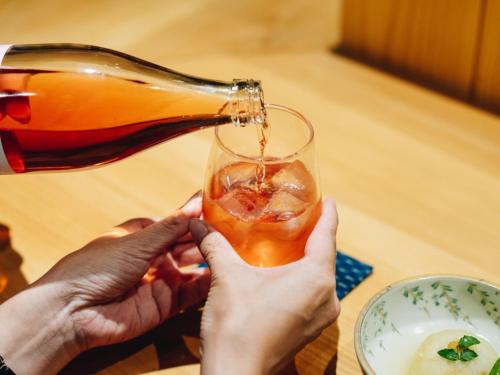 a person pouring a drink into a glass at RITA Yame Fukushima in Yame