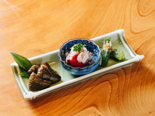 a plate with a bowl of food on a table at RITA Yame Fukushima in Yame
