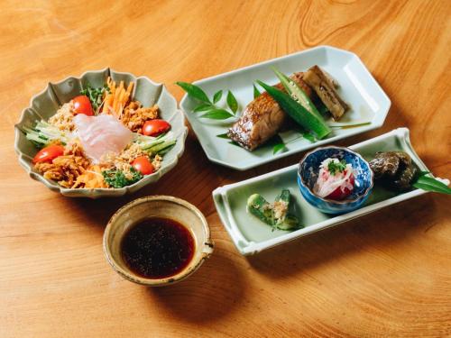 a table with three plates of food and dipping sauce at RITA Yame Fukushima in Yame