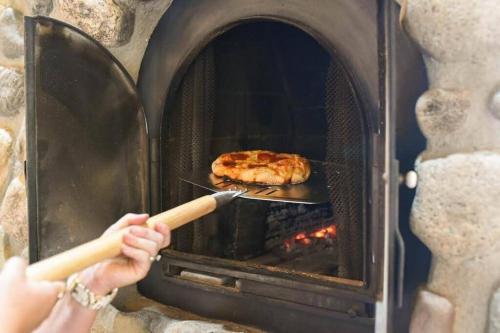 a person is cooking food in an oven at Fairplay Coyote Cabin in Fairplay
