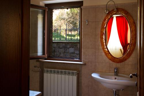 a bathroom with a sink and a mirror and a window at Villa Degli Ulivi in Assisi