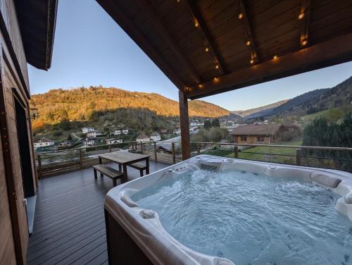 a hot tub on the deck of a house at Casa de Monzel with 6-Person Jacuzzi & Panoramic View in La Bresse