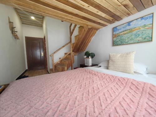 a bedroom with a large bed with a pink blanket at Just waiting for you-Tianmen mountαin-English reception-Book ticket service in Zhangjiajie