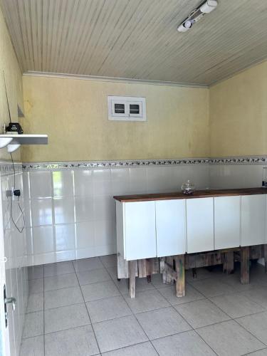 a bathroom with white cabinets and a sink at Casa de Praia Itanhaém in Itanhaém
