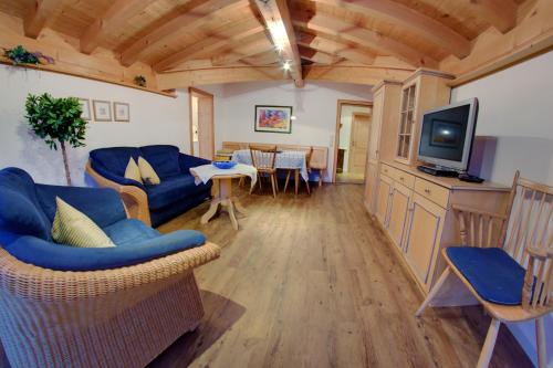 a living room with a blue couch and a tv at Ferienhotel Starennest in Schindelberg