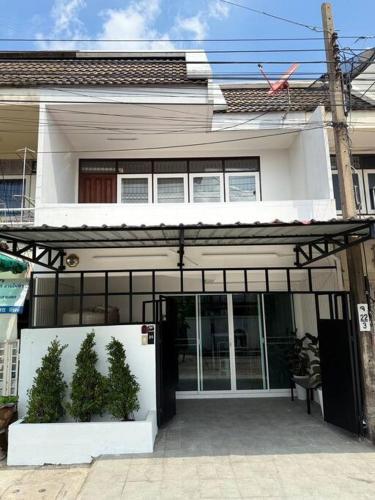 a white house with two plants in front of it at 10MIN 曼谷独栋Chatuchack,Kasetsart精品别墅 MYSTORY HOUSE in Bangkok