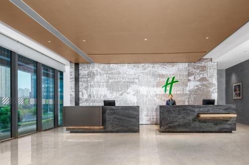 a lobby with a reception desk in a building at Holiday Inn Kunshan East by IHG in Kunshan