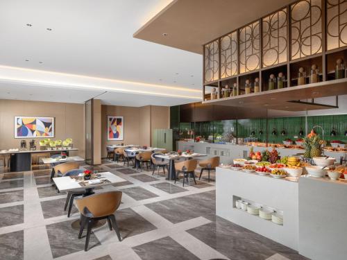 a rendering of a restaurant with tables and chairs at Holiday Inn Kunshan East by IHG in Kunshan
