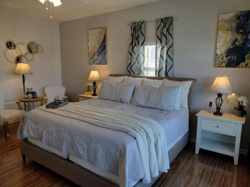 a bedroom with a large bed with two tables and two lamps at Center of Saint Augustine Beach in St. Augustine