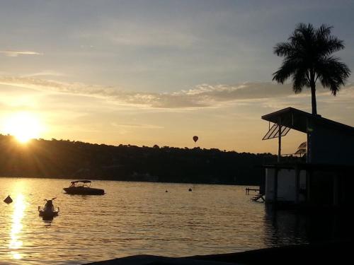 a person in a boat in the water with a hot air balloon at Hotel Los Angeles in Tequesquitengo