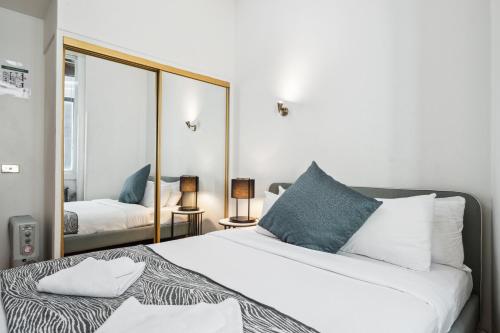 a bedroom with a bed and a large mirror at Cliveden - A Heritage Hideaway with Rooftop Pool in Sydney