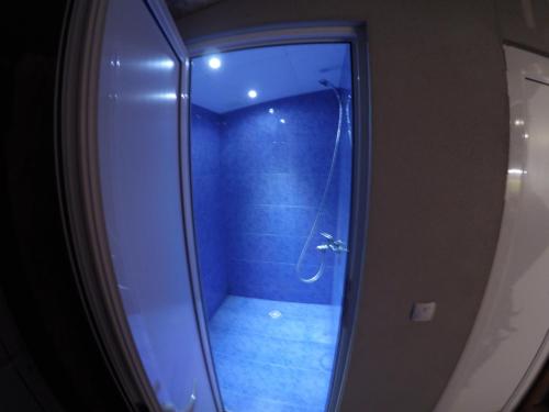 a bathroom with a shower with a blue floor at Hikers Hostel in Plovdiv