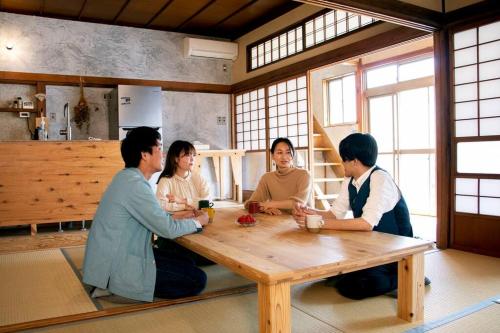 石巻市にあるRoopt OGAWAの木のテーブルの周りに座る人々
