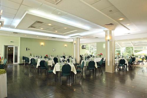 a dining room with tables and chairs and tablesearcher at Hotel Nufarul in Baile Felix