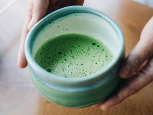 a person holding a cup of green liquid at RITA Yame Fukushima in Yame