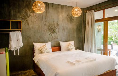 um quarto com uma cama grande e lençóis brancos em Ruean Thai Nai Bang by PANSAK Resort em Surat Thani